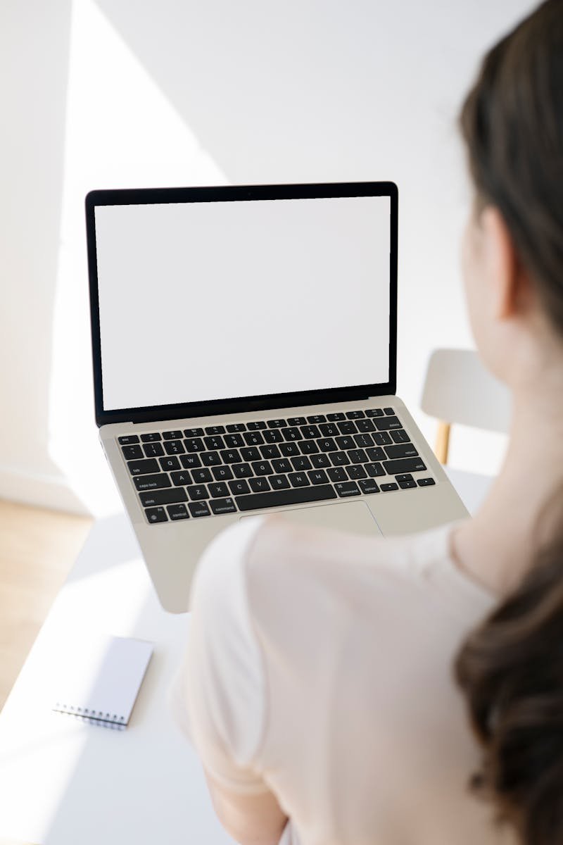 pexels-photo-8532962-8532962 Adult woman in white t-shirt using a blank laptop screen at a modern workspace.